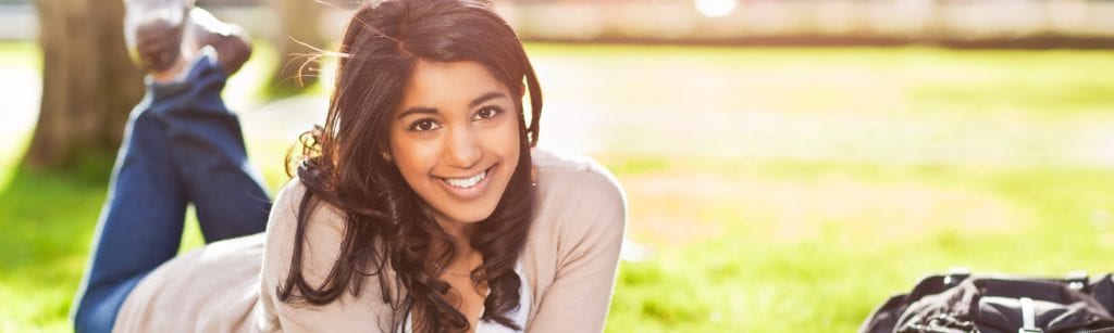 young girl laying on the grass smiling