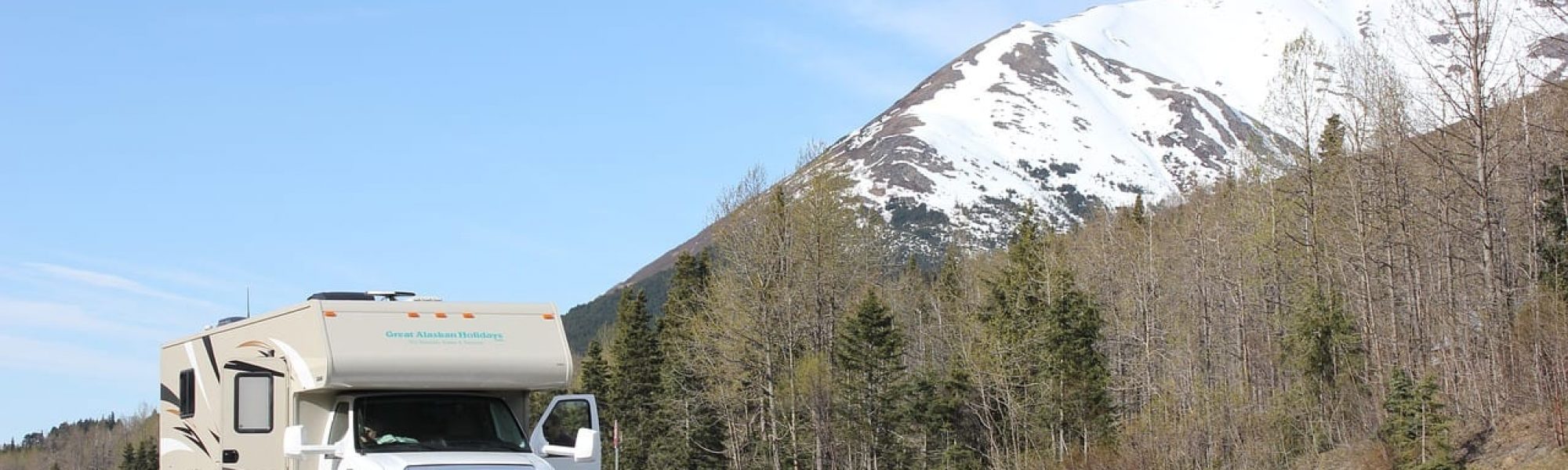 alaska-2178312_1280 recreational vehicle driving along a mountain